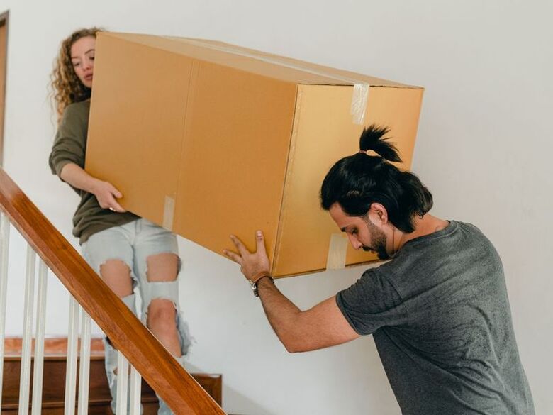 Older two-story home with a front porch and narrow steps on a quiet street